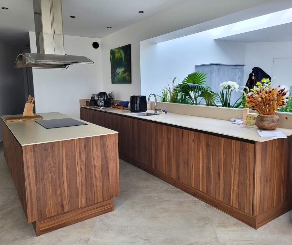 Encimera de cocina Dekton beige con manzana central y mobiliario de madera en proyecto realizado por Mármoles Rustey